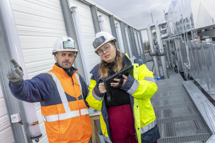 Un homme et une femme échangent sur un chantier d'industrie