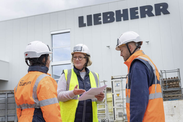 Employés de Tunzini échangeant devant l'usine en construction