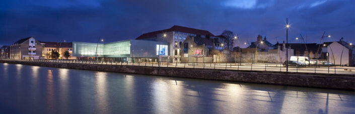 Plan large des quais éclairés avec le musée en fond